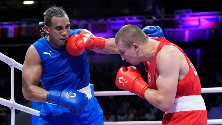 Ukraine's Oleksandr Khyzhniak hits Cuba's Arlen Lopez in their men's...