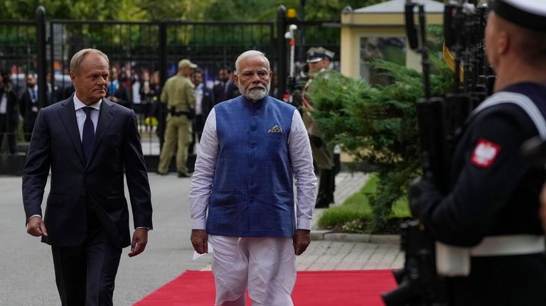 Indian Prime Minister Narendra Modi, right, walks with his Polish...