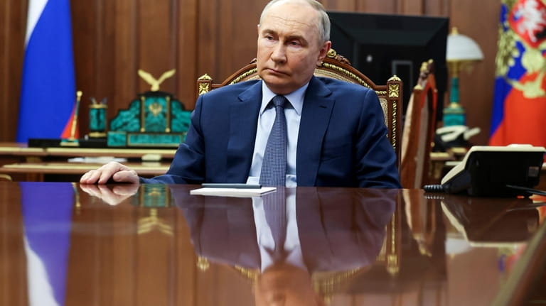 Russian President Vladimir Putin listens to Emergency Situations Minister Alexander...