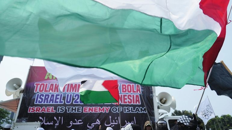 A woman waves a Palestinian flag during a protest in...