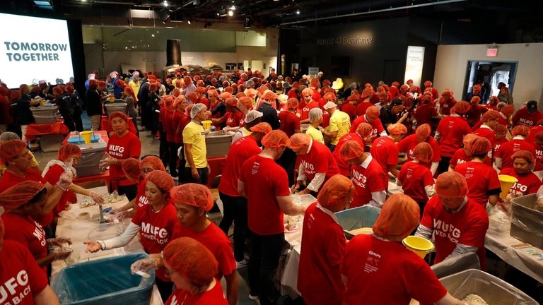 Volunteers package oatmeal for people in need at the Intrepid...