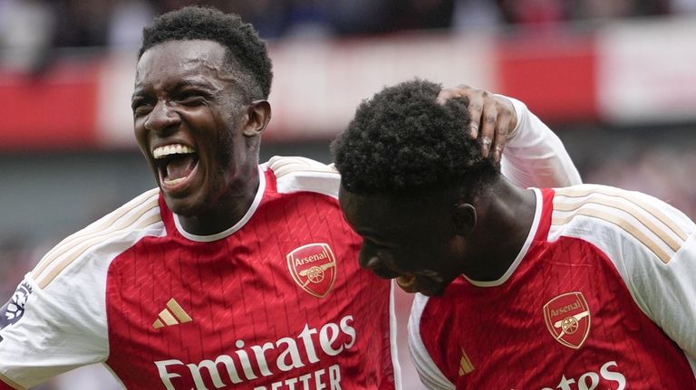 Arsenal's Bukayo Saka, right, celebrates with teammate Arsenal's Eddie Nketiah...