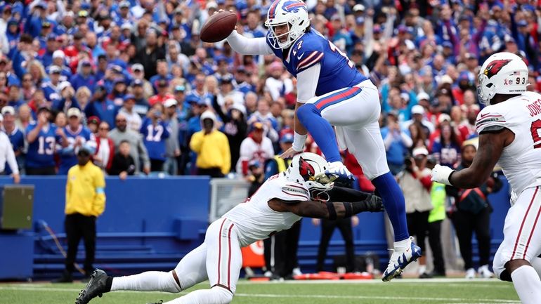 Buffalo Bills quarterback Josh Allen (17) leaps over Arizona Cardinals...