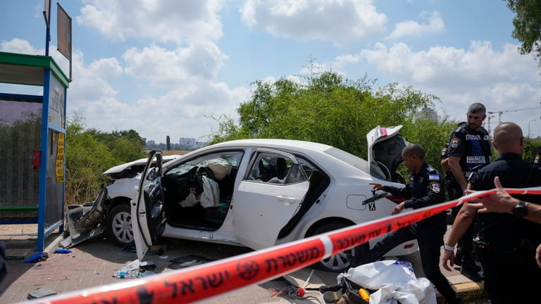 Israeli police officers work at the scene of a suspected...