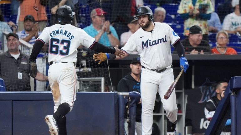 Miami Marlins' Jake Burger, right, congratulates Xavier Edwards (63) after...