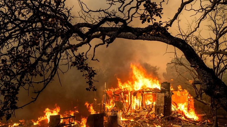 Flames consume a structure on Bessie Lane as the Thompson...