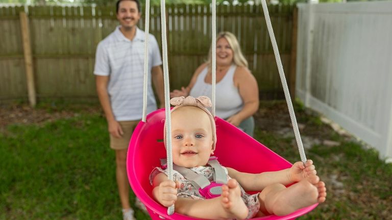 Sam Earle, left, and his wife, Tori, watch their daughter,...