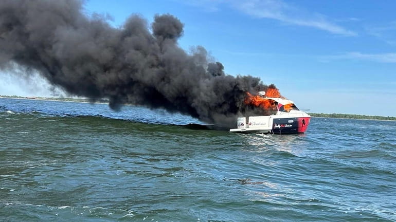 Three men were rescued after their boat caught fire in...