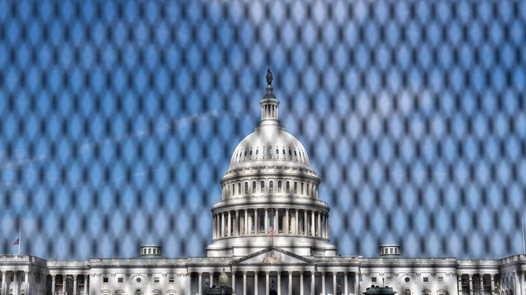 The U.S. Capitol is seen behind a security fence a...