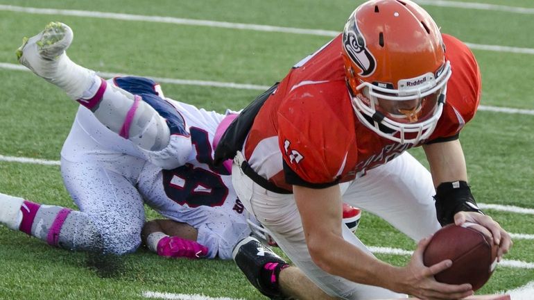 Carey's Michael Catanese leaps over MacArthur's Vin Martino to score...