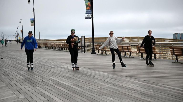 Rollerbladers ride down the Long Beach boardwalk.