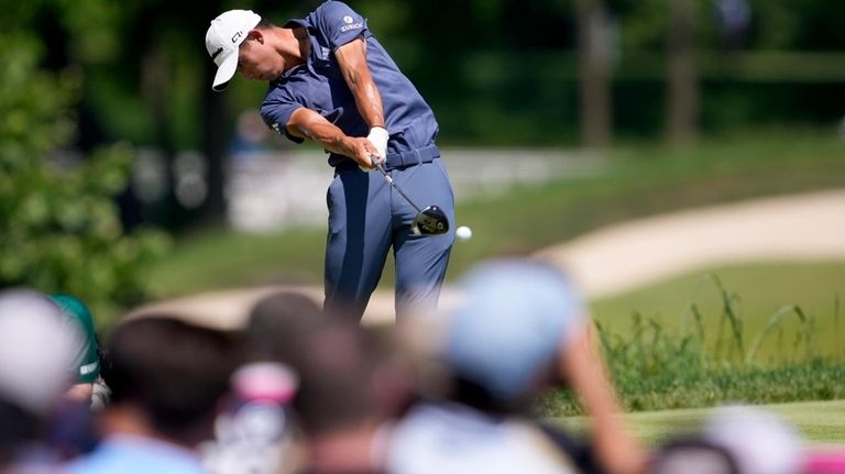 Collin Morikawa hits his tee shot on the fifth hole...