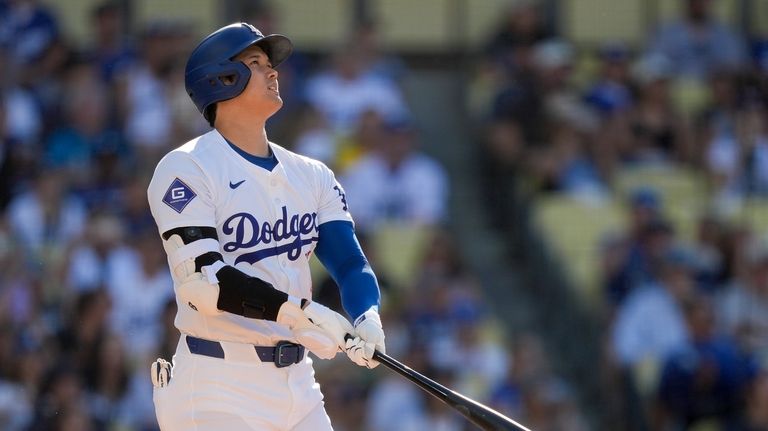 Los Angeles Dodgers designated hitter Shohei Ohtani watches his solo...