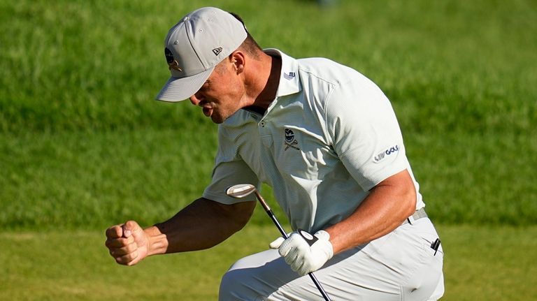 Bryson DeChambeau celebrates after a eagle on the 18th hole...