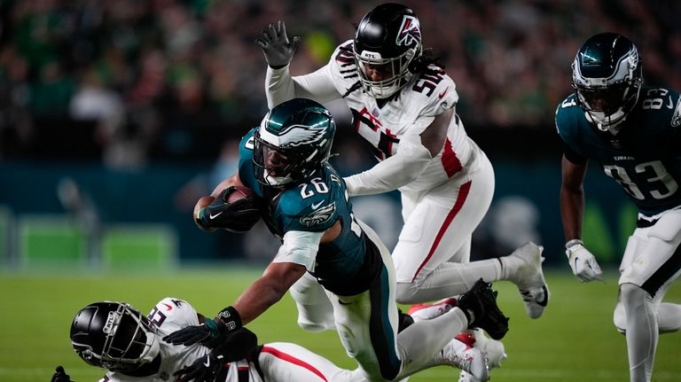 Philadelphia Eagles running back Saquon Barkley (26) falls with the...