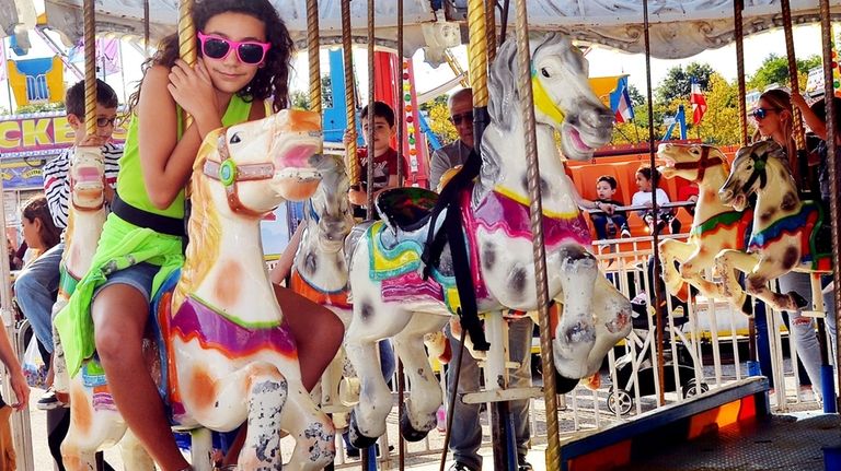 Mariella Andriotis, of Oyster Bay, rides the carousel at the...