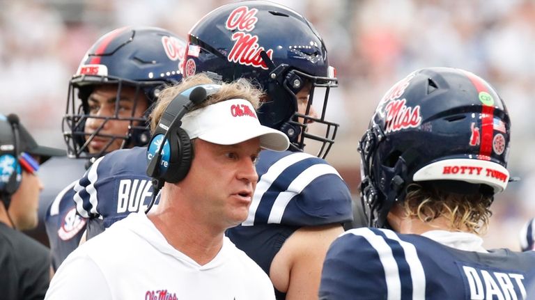 Mississippi head coach Lane Kiffin speaks with quarterback Jaxson Dart...