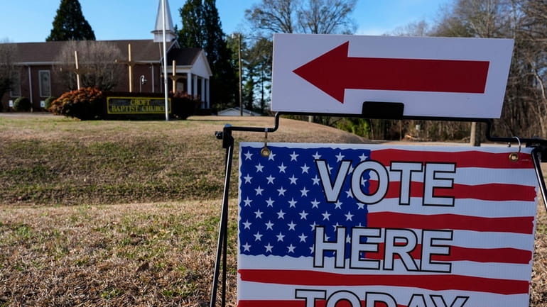 A voting sign is seen near a voting center at...