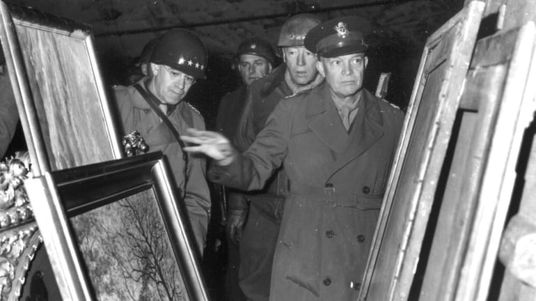 Gen. Dwight D. Eisenhower, center, inspects paintings on April 12,...