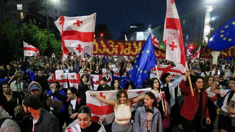 Demonstrators with Georgian national and EU flags rally during an...