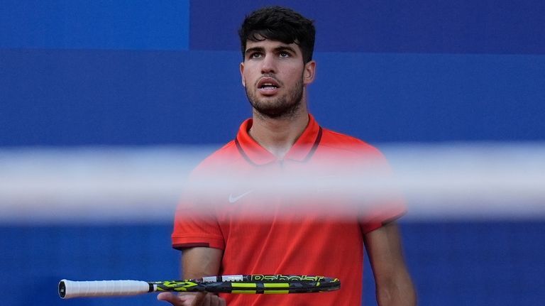 Carlos Alcaraz of Spain spins his racquet as he waits...