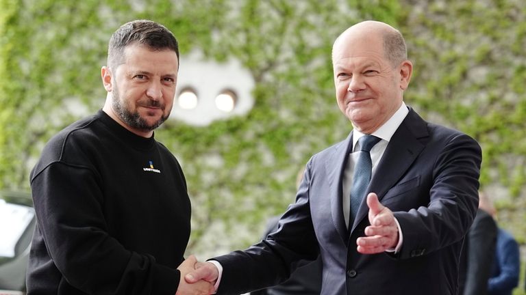 Ukrainian President Volodymyr Zelenskyy, left, is welcomed by German Chancellor...