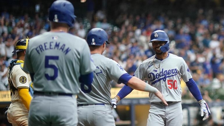 Los Angeles Dodgers' Mookie Betts (50) is congratulated by teammates...