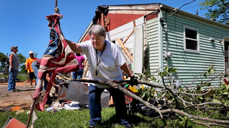 Patti Manley, 69, moves a shredded American flag as she...