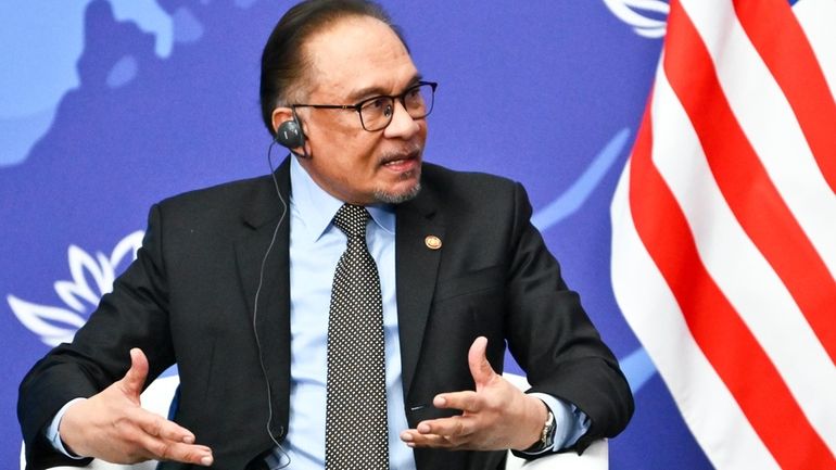 Malaysia's Prime Minister Anwar Ibrahim gestures while speaking to Russian...