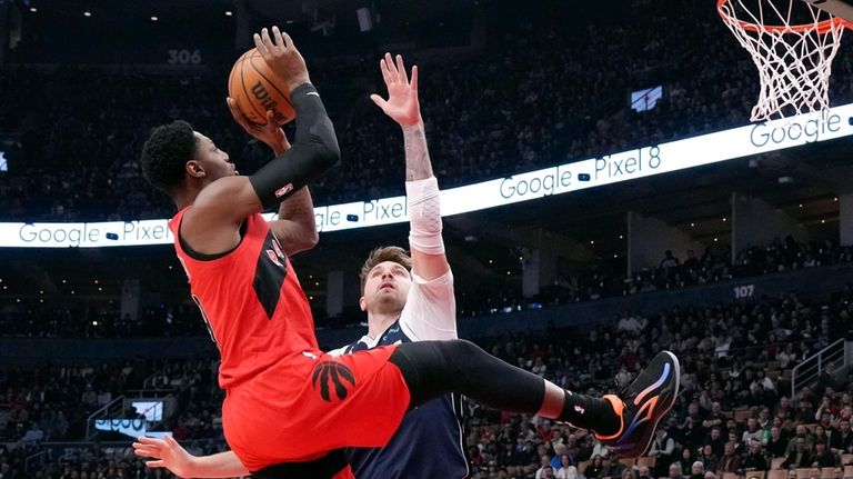 Toronto Raptors' RJ Barrett shoots over Dallas Mavericks' Luka Doncic...