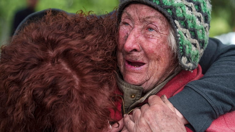 Tetiana, 82, cries with her daughter as she is evacuated...