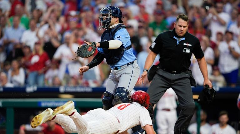 Philadelphia Phillies' Brandon Marsh, bottom, scores past Tampa Bay Rays'...