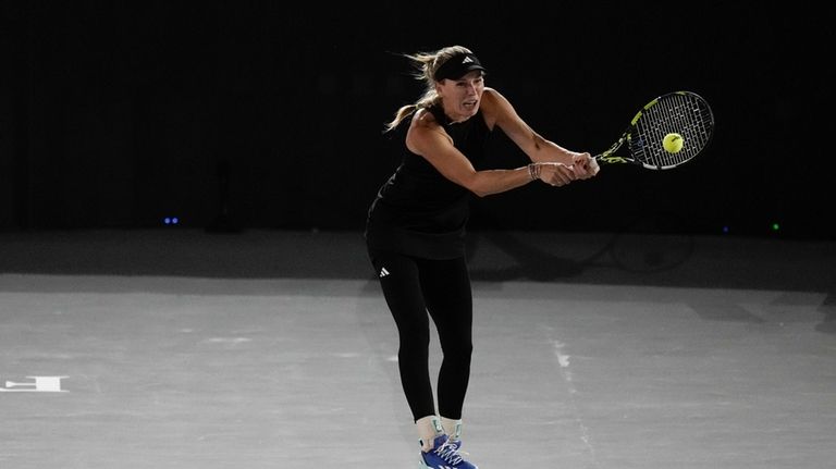 Caroline Wozniacki, of Denmark, returns the ball during an exhibition...