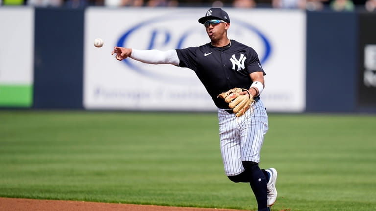 New York Yankees shortstop Oswald Peraza throws to first base...