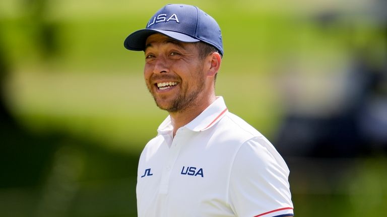 Xander Schauffele, of the United States, smiles on the 13th...