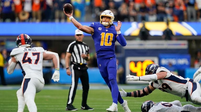 Los Angeles Chargers quarterback Justin Herbert (10) throws under pressure...