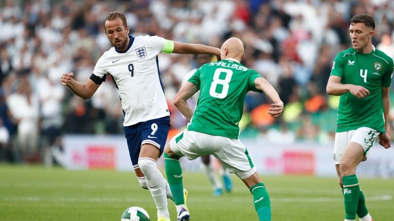 England's Harry Kane, left ,get past the challenge of Ireland's...