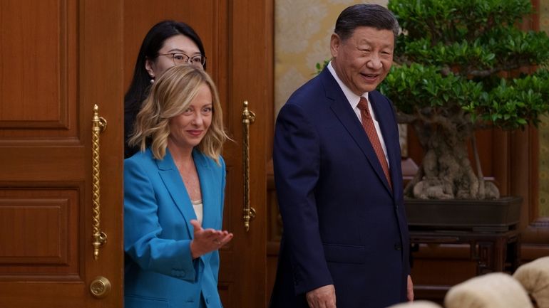 Chinese President Xi Jinping, right, walks with Italian Premier Giorgia...