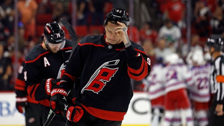 FILE- Carolina Hurricanes' Evgeny Kuznetsov (92) and Jaccob Slavin (74)...