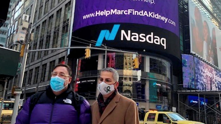 Marc Weiner, left, stands in front of his Times Square billboard...