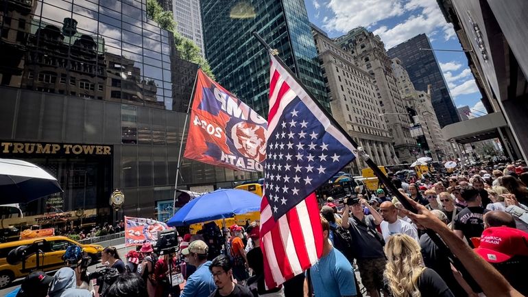 A supporter of former President Donald Trump waves an inverted...