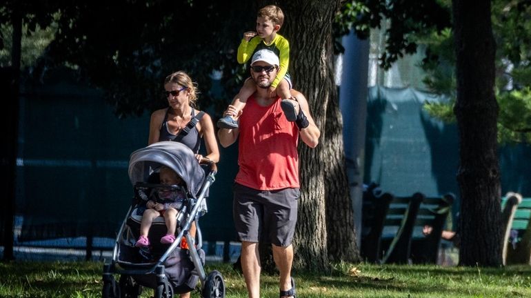 A family enjoying a walk at Eisenhower Park in East...