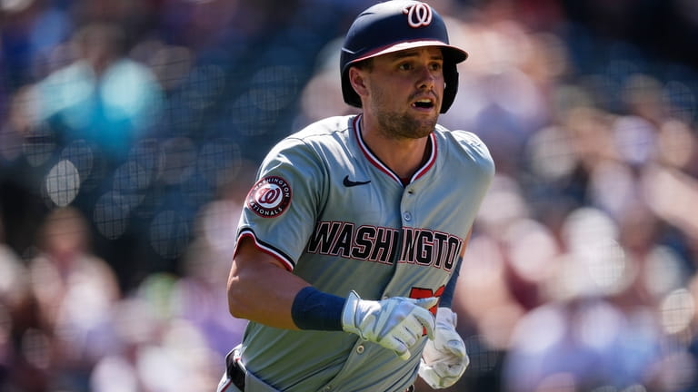 Washington Nationals' Lane Thomas heads up the first-base line after...