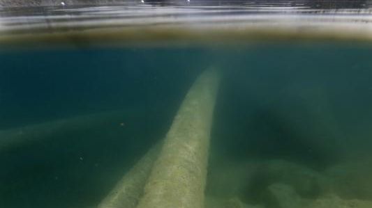 Pipes carry water into and out of a rock quarry...