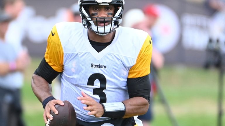 Pittsburgh Steelers quarterback Russell Wilson scrambles out of the pocket...