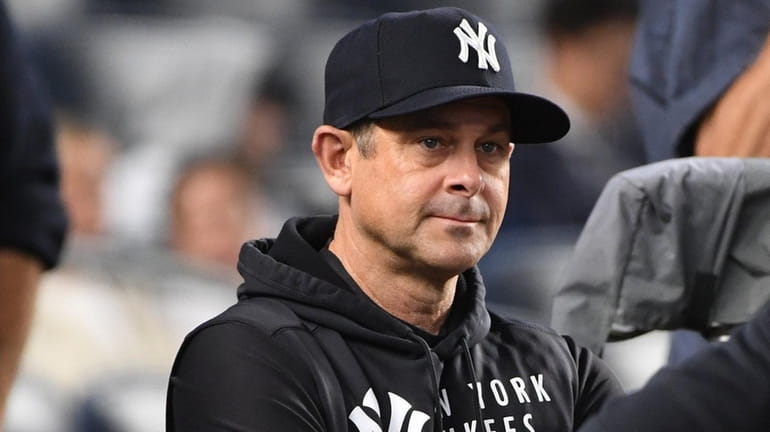 Yankees manager Aaron Boone looks on from the dugout before...