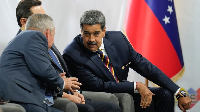 Venezuelan President Nicolas Maduro, right, speaks with presidential candidate Luis...