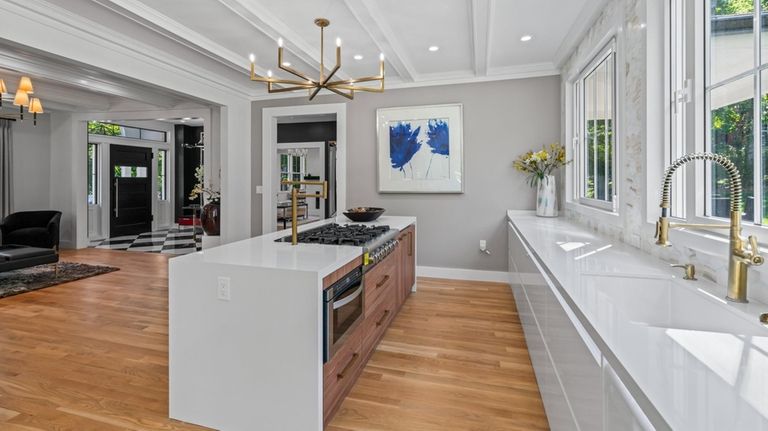 The kitchen sports white lacquer cabinets and quartz countertops.