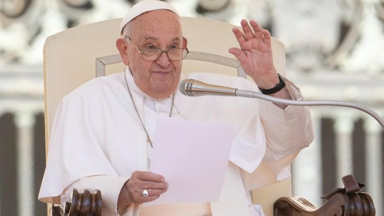 Pope Francis waves during his weekly general audience in the...