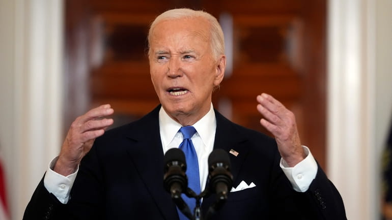 President Joe Biden speaks in the Cross Hall of the...
